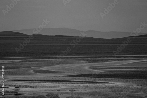 Seascape with mountains in background, black and white