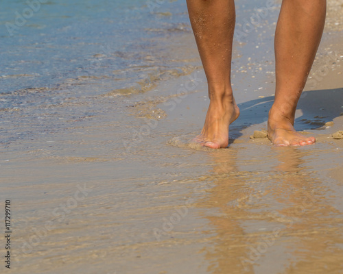 Sexy legs on the beach. Walking female feet