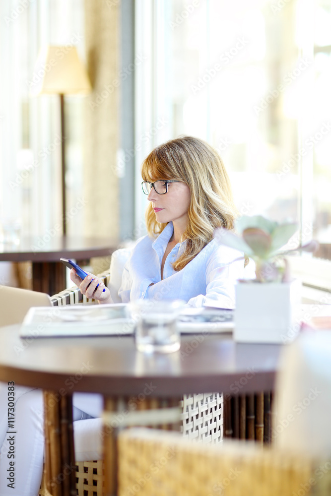 Sending message. Mature woman relaxing at home. Sending message. Mature woman relaxing at home.