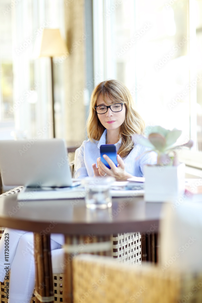 Sending message. Mature woman relaxing at home. Sending message. Mature woman relaxing at home.