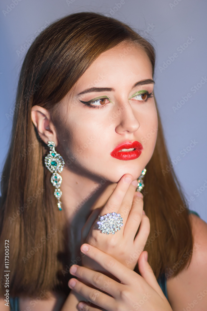 Elegant Posh Woman with Diamond Earrings. Platinum Jewelry with green Diamonds. Soft focus