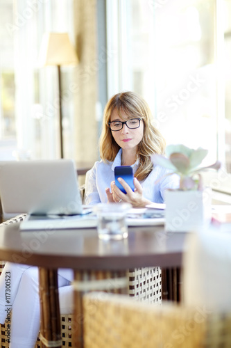 Sending message. Mature woman relaxing at home. © sepy