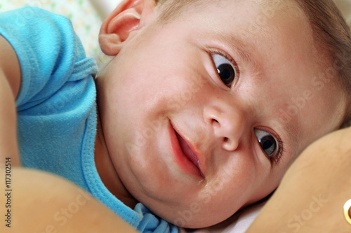 retrato de un hermoso bebe feliz sonriendo con su madre en la cama.