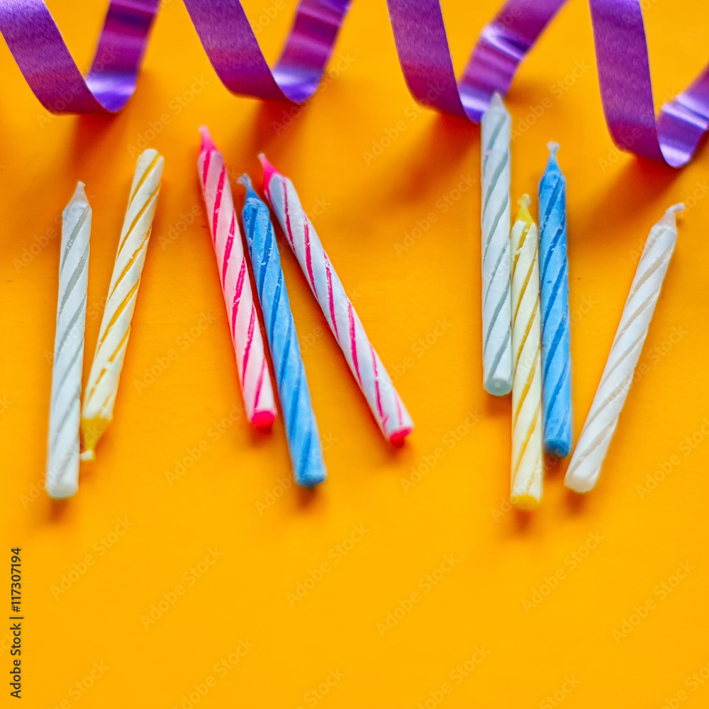 Fototapeta premium Candles and streamer on yellow background. Preparing for a birthday