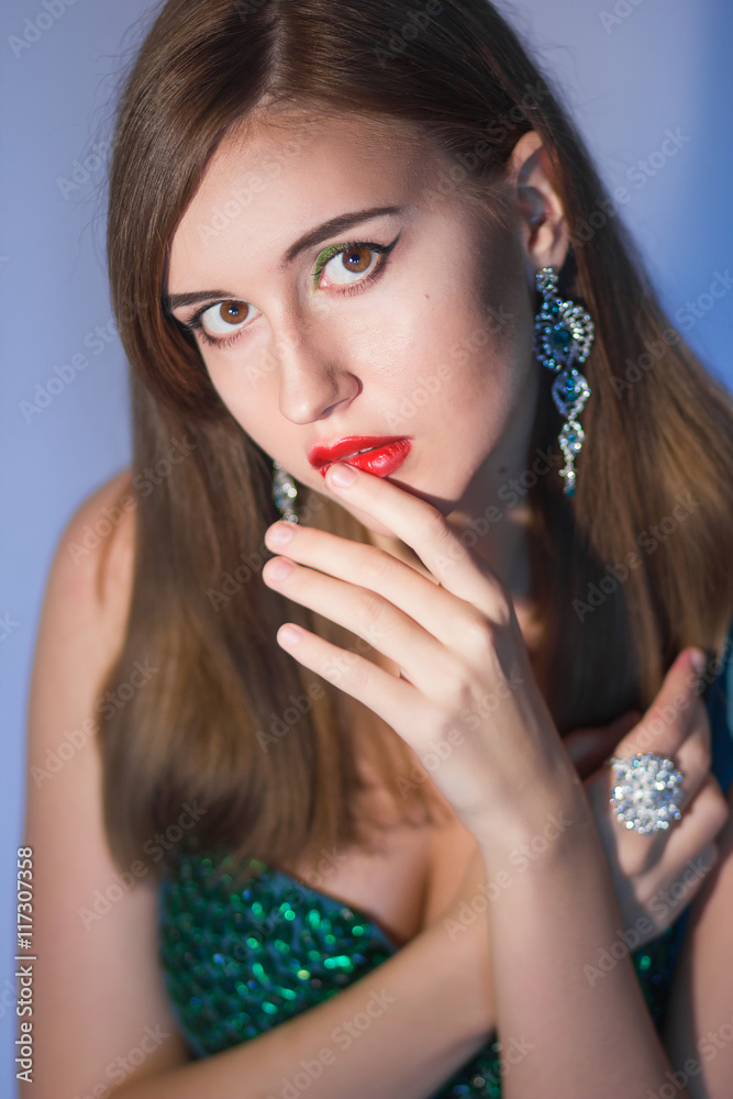 Elegant Posh Woman with Diamond Earrings. Platinum Jewelry with green Diamonds. Soft focus Elegant Posh Woman with Diamond Earrings. Platinum Jewelry with green Diamonds. Soft focus