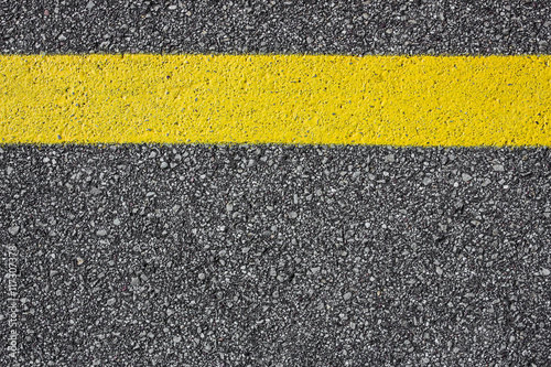 Yellow paint line on asphalt background. © Paweł Michałowski