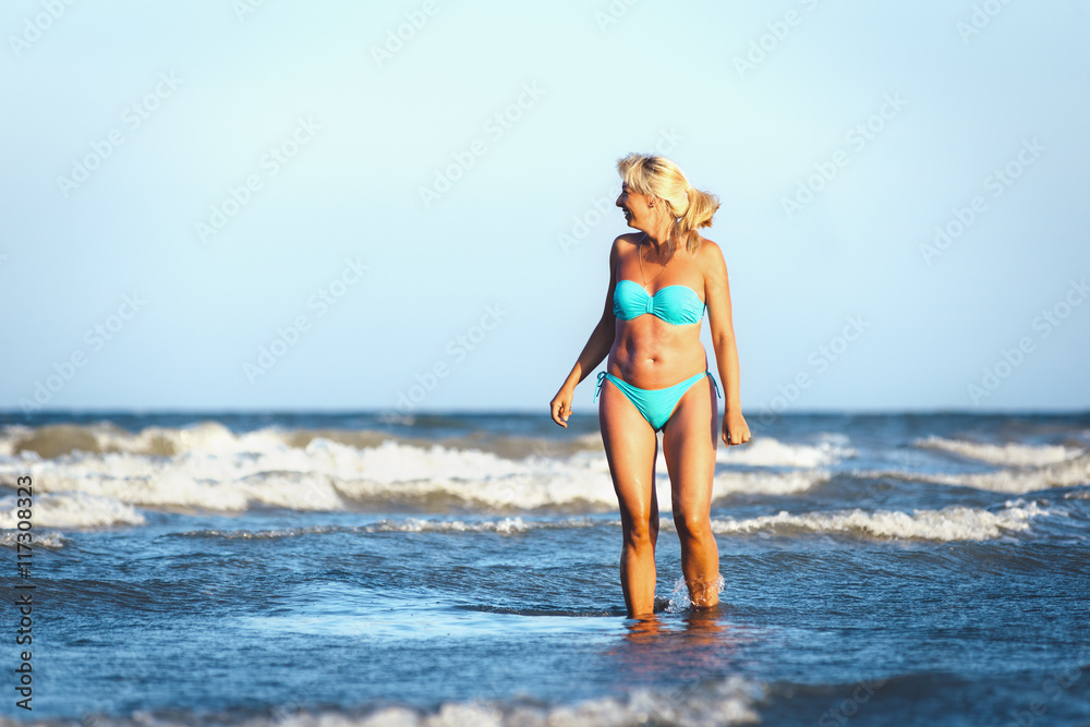 The girl in a swimsuit walking on the waves The girl in a swimsuit walking on the waves