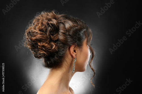 Young beautiful woman with nice hairdo on dark background