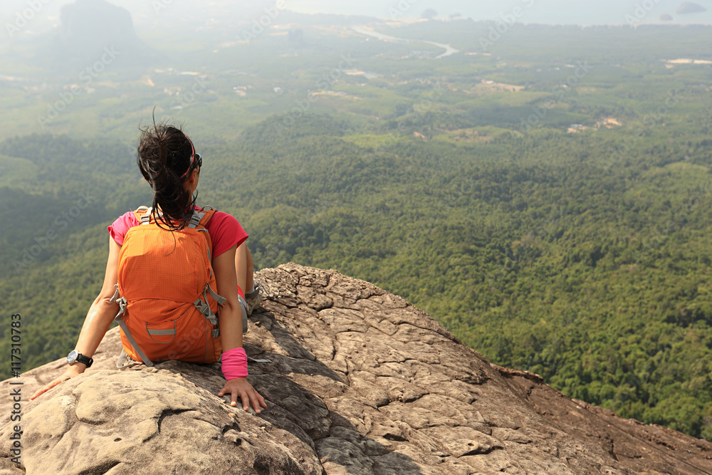 Obraz premium young asian woman hiker enjoy the view on mountain peak cliff