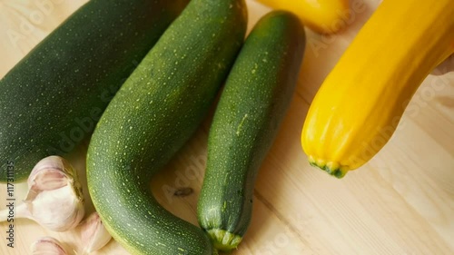Woman hands cleaning the kitchen knife yellow zucchini