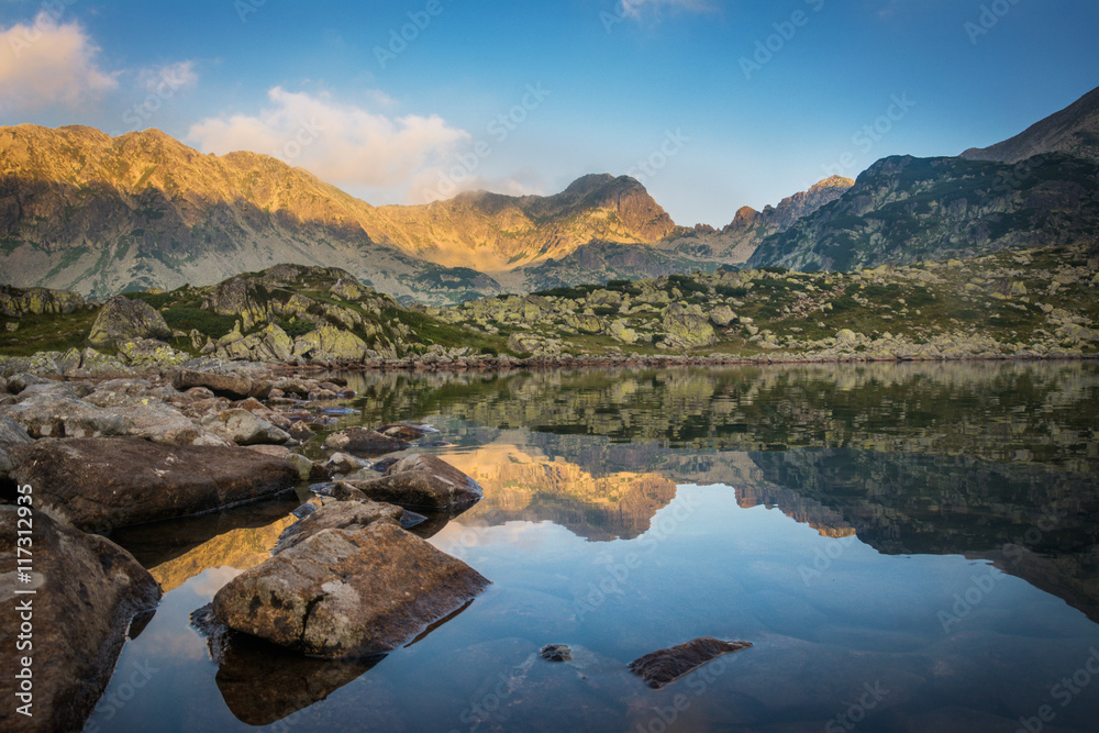 Beautiful colorful sunset over Bucura glacial lake and Retezat National Park, Romania