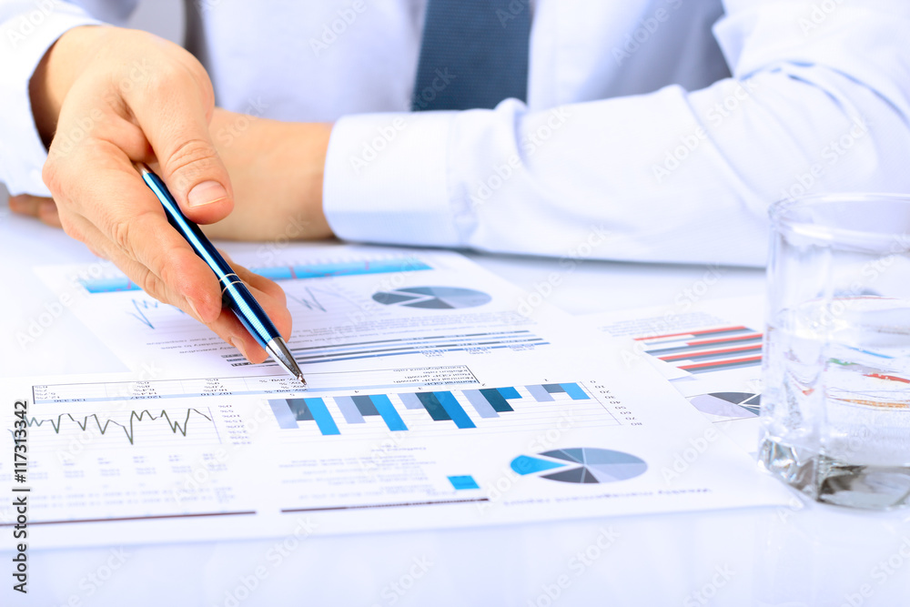 Close-up Of Businessman Analyzing Graphs Close-up Of Businessman Analyzing Graphs
