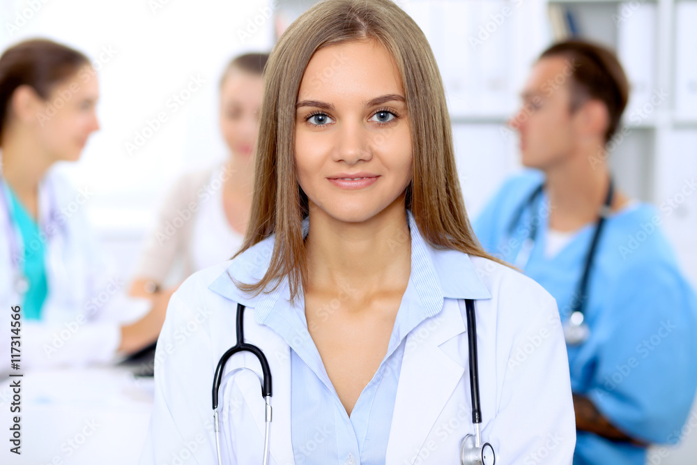 Happy doctor woman with medical staff at the hospital sitting at the table and discussing medical history Happy doctor woman with medical staff at the hospital sitting at the table and discussing medical history