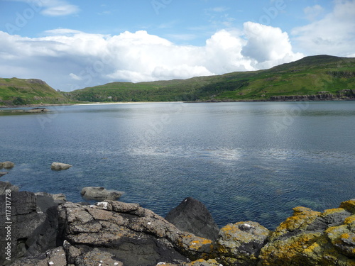 View across Calgary Bay, Isle of Mull, Scotland with clouds reflected in the calm blue waters of the Bay