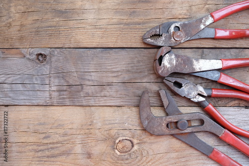 pliers set red handle over a wood panel. Top view with copy space.