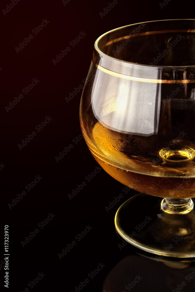 Shot glass with alcohol against a dark background. Shot glass with alcohol against a dark background.