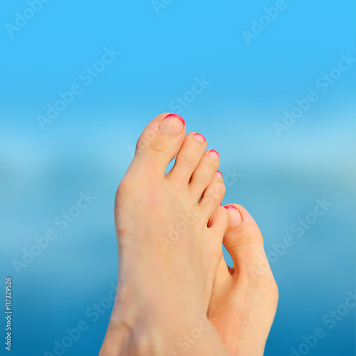 Woman feet closeup of girl relaxing on beach on sunbed