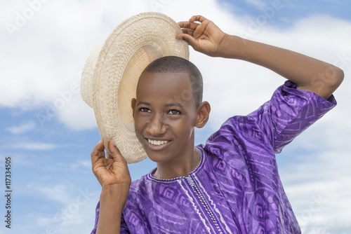 Wall Mural Smiling teenager holding a boater straw hat
