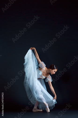 Fototapeta Naklejka Na Ścianę i Meble -  Portrait of the classical ballerina in white dress on black background