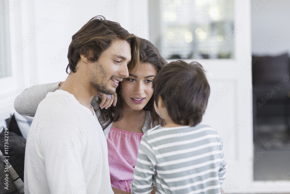 Happy young family sitting on couch in living room Happy young family sitting on couch in living room