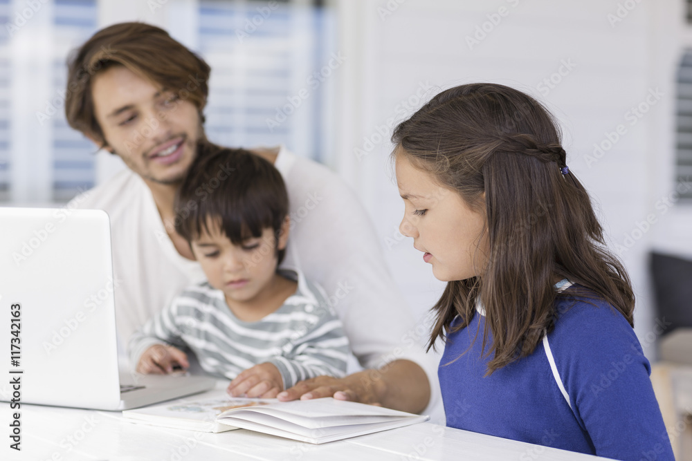 Father teaching to children about world map while using laptop at home Father teaching to children about world map while using laptop at home