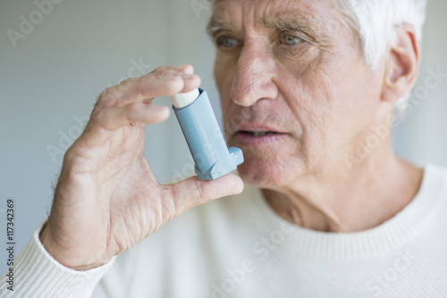 Close-up of a senior man using inhaler