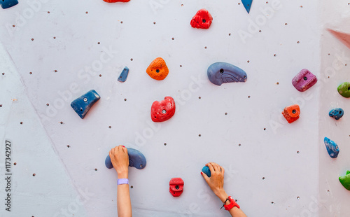 Climber young woman starting bouldering track on artificial wall indoor, hands closeup photo