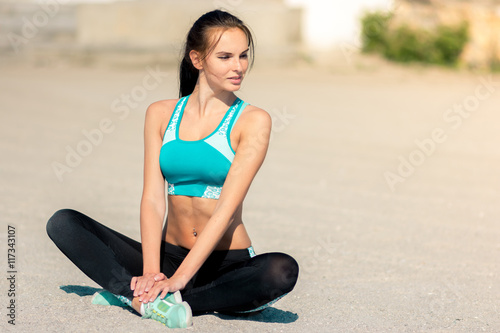 Athletic woman stretching exercise training fitness on a beach s