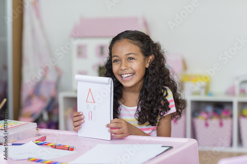 Happy little girl showing her drawing