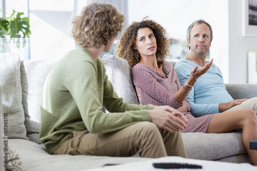 Happy family talking in a living room at home Happy family talking in a living room at home