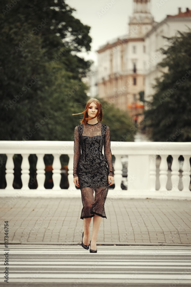 Attractive girl in black dress crossing the street Attractive girl in black dress crossing the street