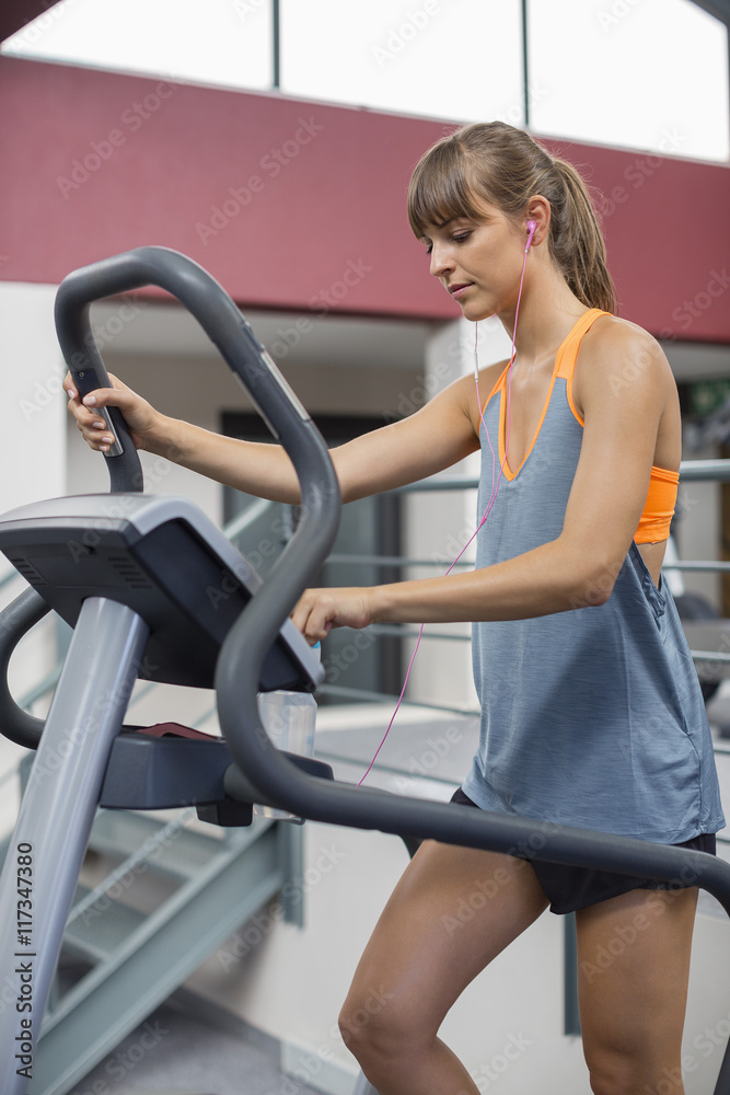Young woman exercising on a machine in a fitness club