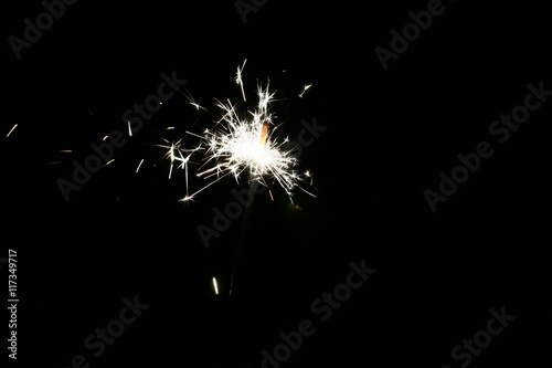Photograph of the sparkler with bright sparks on a black background