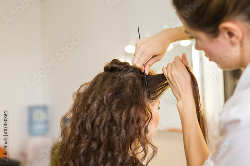 working day inside the beauty salon. Hairdresser makes hair styling.