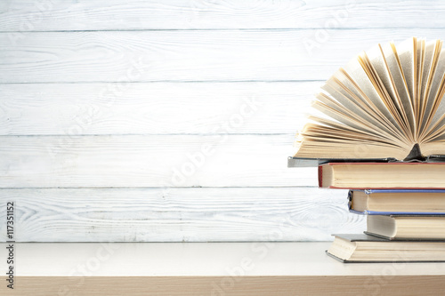 Open book, hardback books on wooden table. Education background. Back to school. Copy space for text.