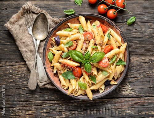 pasta with meat and basil on a plate on a wooden background Fototapet