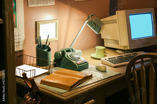 Retro office desk in dark room with simulator object.