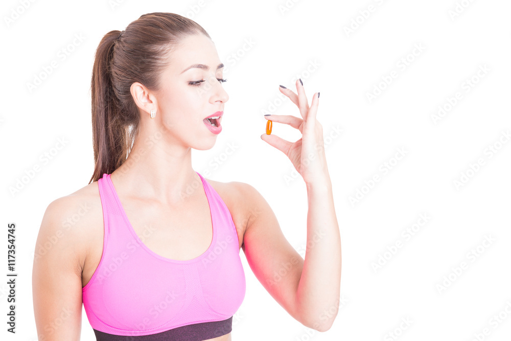 Young female wearing sportswear taking slimming pill Young female wearing sportswear taking slimming pill