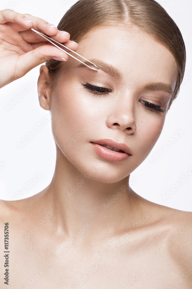 Beautiful young girl with a light natural make-up, Eyebrow Tweezers and French manicure. Beauty face.