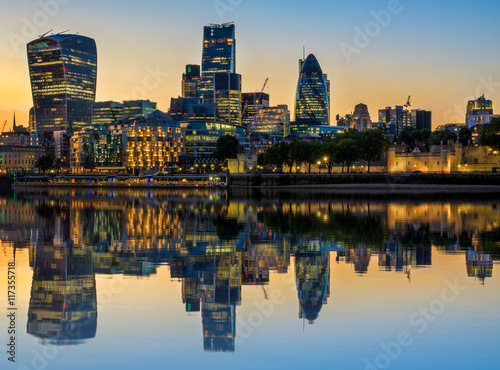 Illuminated London cityscape at sunset with reflection from river Thames