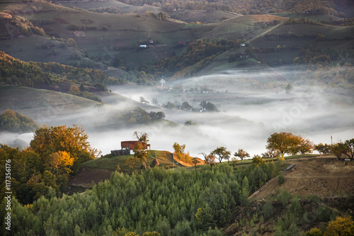 Scenery of idyllic countryside hills with fog on autumn morning