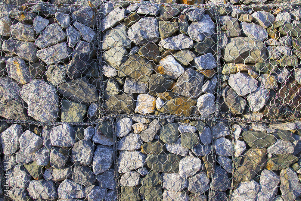 Wire Gabion Rock Fence. Metal Cage filled with rocks. Texture background of rock fence with cage. Wire Gabion Rock Fence. Metal Cage filled with rocks. Texture background of rock fence with cage.