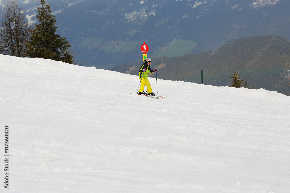 Skiing girl in ski mask and helmet on Dachstein resort in Austria Alps.