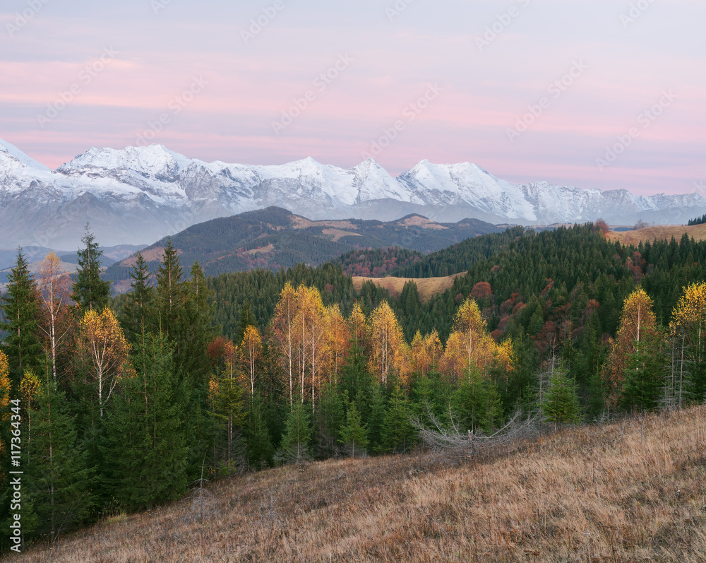 Autumn landscape with mountain peaks in snow