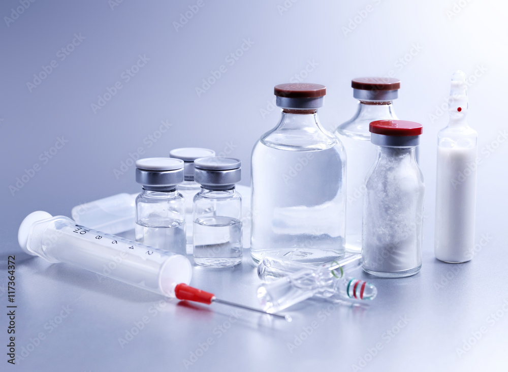 Vials and syringe, studio shot. Medical objects for vaccination. Vaccine drew up into a syringe. Vials and syringe, studio shot. Medical objects for vaccination. Vaccine drew up into a syringe.