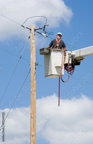 Utility Worker Fixing Power Lines – An electrical utility worker fixes the power lines.