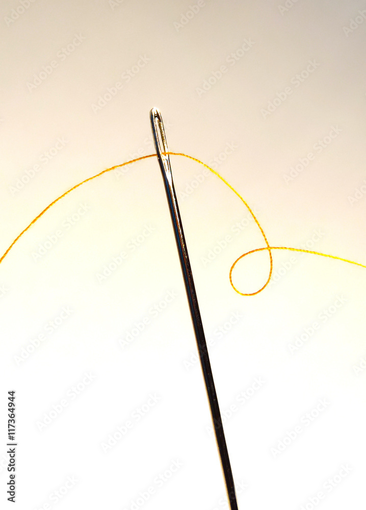 Needle and thread, close-up shot. Sewing background. Needle and thread, close-up shot. Sewing background.
