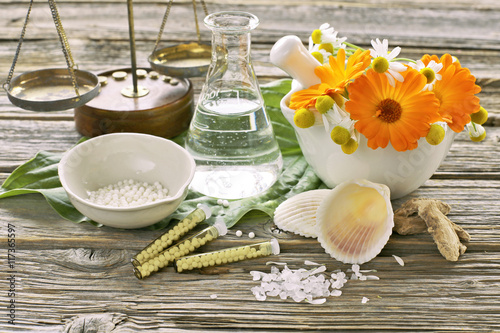 Camomile  with calendula in mortal  with  scales  on wooden background 