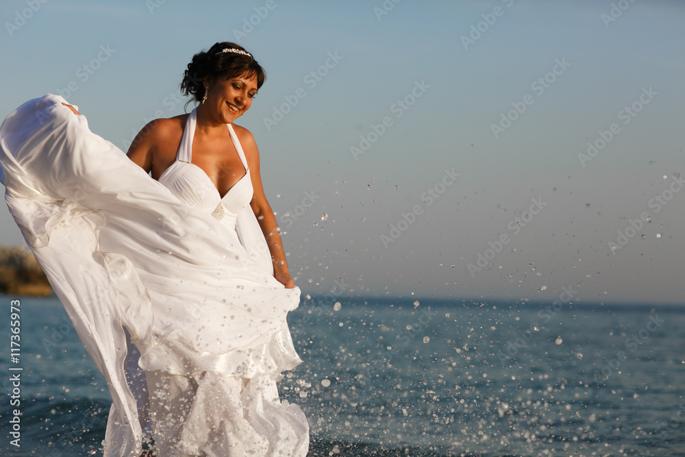 Splashes of sea water cover a beautiful bride Splashes of sea water cover a beautiful bride