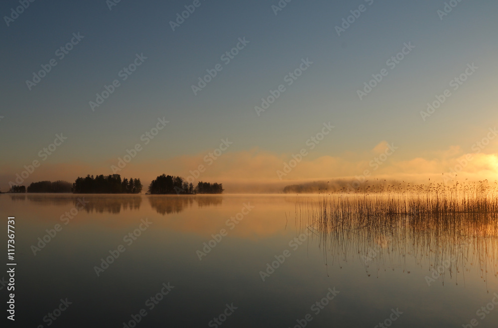 Sunrise on the lake with haze.